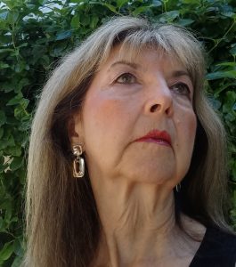 Michelle Lamothe, woman in make up staring off into the distant with plants in the background